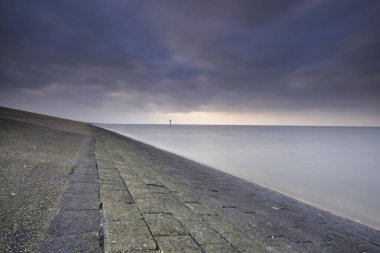 Hollanda, Moddergat 'taki hendekten etkileyici bir manzara. Taş, su ve havadan oluşan güzel bir bileşim. Wadden Denizi üzerinde gün batımı. Unesco Dünya Mirası.