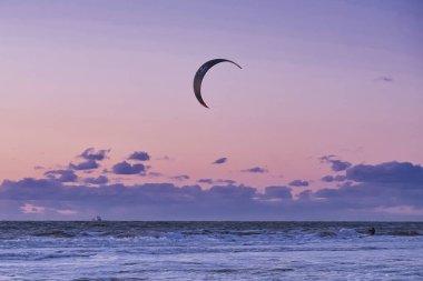 Extreme Sport Kitesurfing, ufukta kargo gemileri. Gün batımında Scheveningen 'de denizde sörfçü..