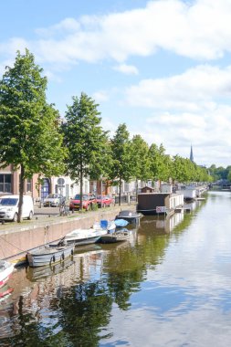 Lahey, Hollanda - 15 Mayıs 2020: Tekne ve ağaçların yansımasıyla kanal, Lahey, Hollanda 'da araba ve evlerle dolu sokak