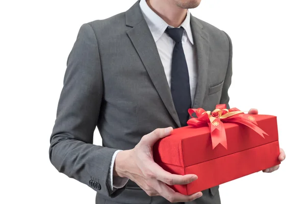 Empresario sosteniendo una caja de regalo roja aislada sobre fondo blanco . — Foto de Stock