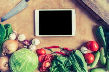 Tablet ile taze sebze üstten görünüm dokunma bilgisayar gadget'ı ahşap masa arka plan.
