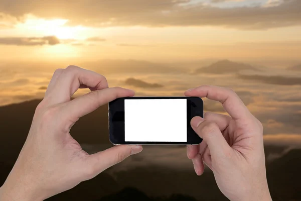 Чоловічі руки тримають мобільний телефон з сенсорним порожнім білим екраном на розмитому фоні природи . — стокове фото
