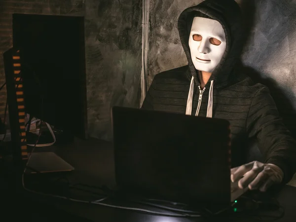 Computer hacker - Uomo in felpa con cappuccio con maschera rubare i dati dal computer portatile — Foto Stock