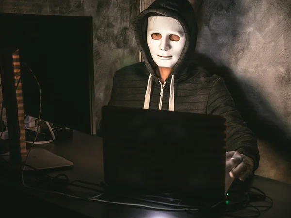 Computer hacker - Uomo in felpa con cappuccio con maschera rubare i dati dal computer portatile — Foto Stock