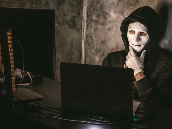 Computer hacker - Uomo in felpa con cappuccio con maschera rubare i dati dal computer portatile — Foto Stock