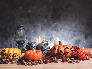 Mum ışığı ve kafatasları koyu arka plan üzerinde Halloween kabaklar