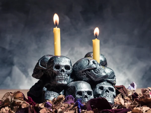 Calaveras con velas ardiendo y flores secas sobre fondo oscuro . —  Fotos de Stock