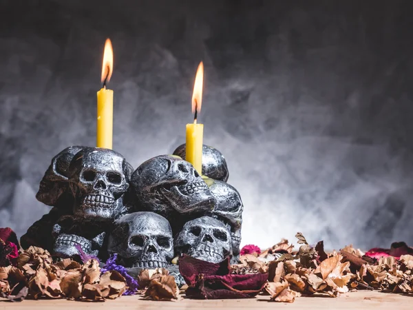 Calaveras con velas ardiendo y flores secas sobre fondo oscuro . —  Fotos de Stock