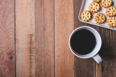 Ahşap masa arka plan üzerinde üstten görünüm tanımlama bilgisi ve kahve fincanı. Metin için boş alan