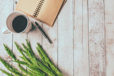 Beyaz ahşap masa arka plan üzerinde boş defter, kalem ve çeltik pirinç ile Kahve fincan üst görünümü, metin için boş alan, Vintage sesi