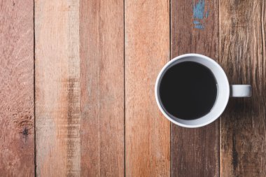 Ahşap masa arka plan üzerinde Kahve fincan üst görünümü. Metin için boş alan