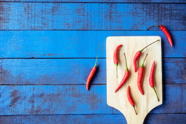 Tepsi ahşap masa mavi arka plan, metin için boş alan üzerinde kırmızı sıcak biber biber Üstten Görünüm