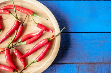 Tepsi ahşap masa mavi arka plan, metin için boş alan üzerinde kırmızı sıcak biber biber Üstten Görünüm