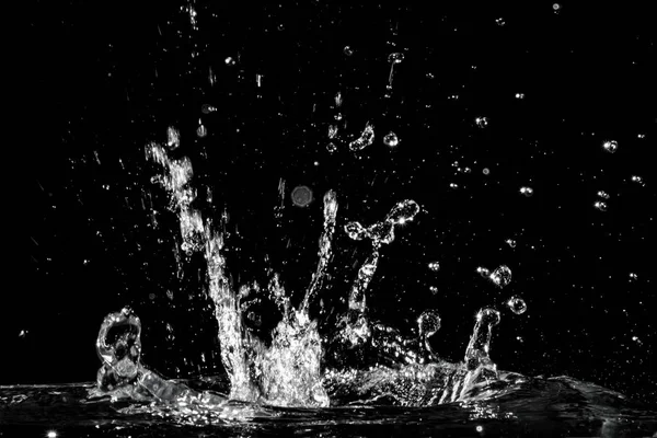 Acqua spruzzata isolata su fondo nero — Foto Stock