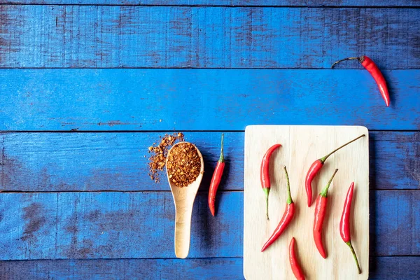 Vista superior de pimientos rojos picantes con cayena sobre fondo de mesa de madera azul, espacio libre para texto — Foto de Stock