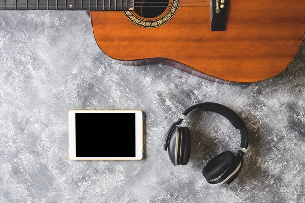 Grunge arka plan üzerinde kulaklık ve tablet ile gitar Üstten Görünüm