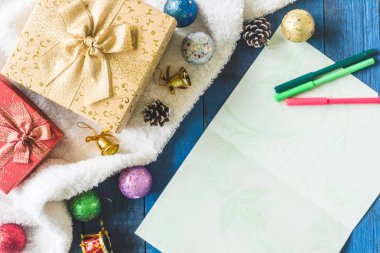 Hediye kutuları Noel dekorasyonu ve kartı ile üstten görünüm ahşap masa arka plan üzerinde.