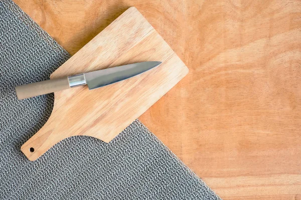 Нож и доска для рубки на деревянном фоне стола . — стоковое фото
