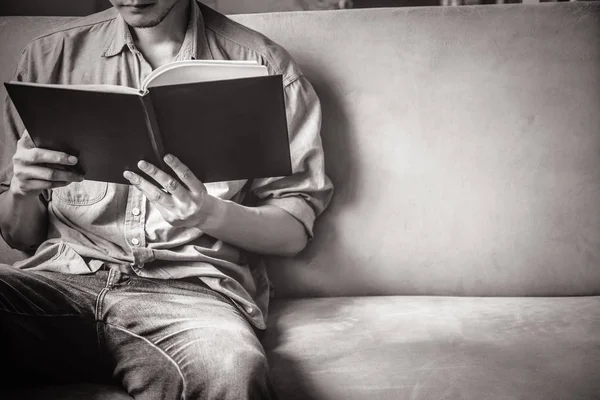 休闲的年轻男子在家里的沙发上阅读文档. — 图库照片