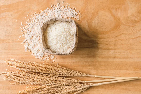 Вид зверху на зерно сирого рису та сухий рисовий завод на дерев'яному фоні столу . — стокове фото