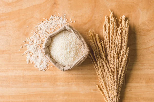 Вид зверху на зерно сирого рису та сухий рисовий завод на дерев'яному фоні столу . — стокове фото