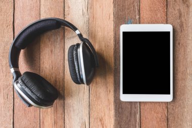 Ahşap masa arka plan üzerinde kulaklık Tablet ile Üstten Görünüm