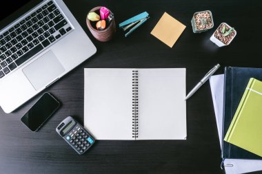 Masanın üzerinde Üstten Görünüm boş dizüstü dizüstü bilgisayar ve ofis malzemeleri.