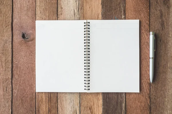 Bovenaanzicht van lege notebook met pen op houten tafel achtergrond. — Stockfoto