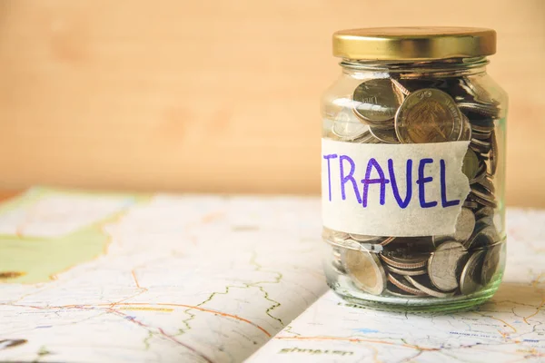 地図にガラスの瓶にコイン 旅行の概念のためのお金を節約 — ストック写真
