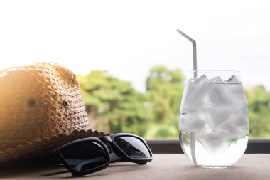 Su buz küpleri, şapka ve güneş gözlüğü masada.