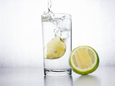 Beyaz arka plan üzerinde limonlu su.