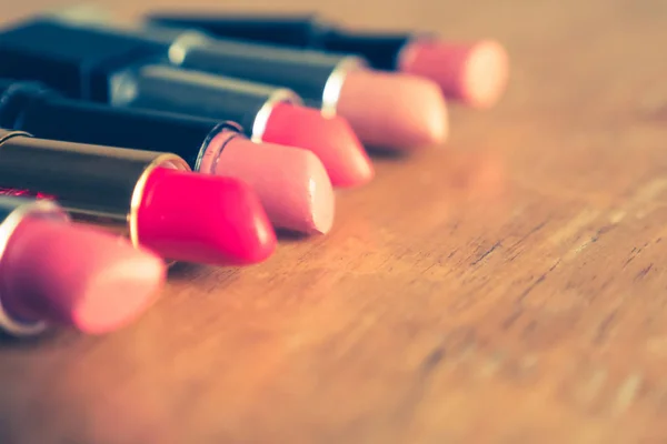 Batons coloridos na mesa de madeira. Maquiagem e conceito de beleza. Foco seletivo — Fotografia de Stock