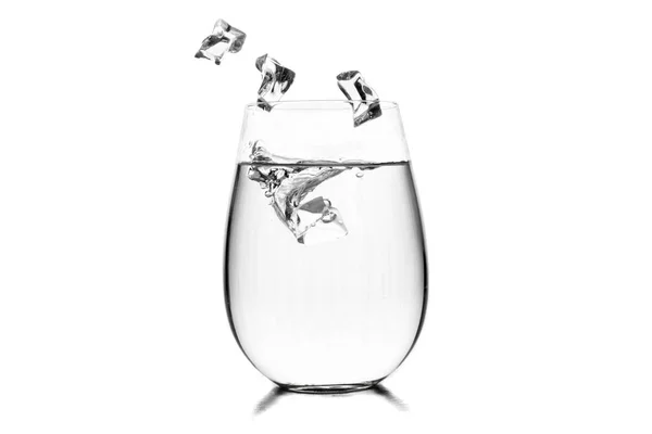 Vidro de água com cubos de gelo sobre fundo branco. — Fotografia de Stock