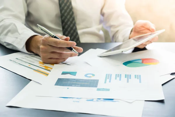 stock image Close up of Businessman analyzing investment charts and using tablet on the desk.