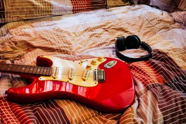 Elektro gitar ve kulaklık yatak odasında, filtre film tahıl.