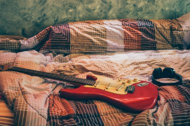 Elektro gitar ve kulaklık yatak odasında, filtre film tahıl.