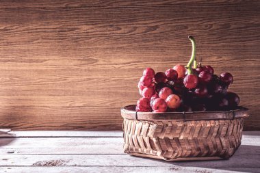 Kırmızı üzüm sepeti ahşap masa üzerinde. Metin için boş alan