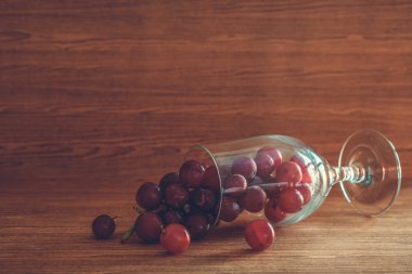 Kırmızı üzüm cam ahşap masa üzerinde. Metin için boş alan