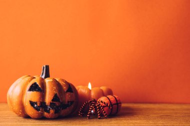 Halloween pumpkins bir turuncu renk arka plan üzerinde mum ışığı ile. Metin için boş alan