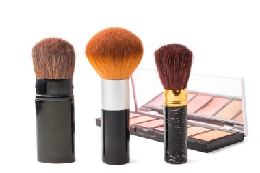 Makyaj fırçaları ve beyaz zemin üzerine palet.