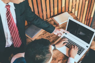 Bir dizüstü bilgisayarda çalışan iki iş adamı. üst düzey ve küçük bir işadamı bir şey onların toplantı sırasında tartışmak.