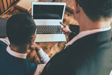 Bir dizüstü bilgisayarda çalışan iki iş adamı. üst düzey ve küçük bir işadamı bir şey onların toplantı sırasında tartışmak.