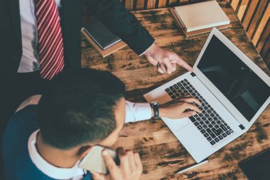 Bir dizüstü bilgisayarda çalışan iki iş adamı. üst düzey ve küçük bir işadamı bir şey onların toplantı sırasında tartışmak.