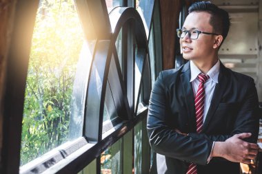 Office pencereden dışarı bakarak mutlu Asya işadamı.