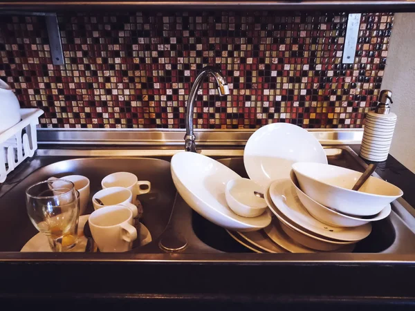Viele Küchenutensilien für die Reinigung im Spülbecken. — Stockfoto