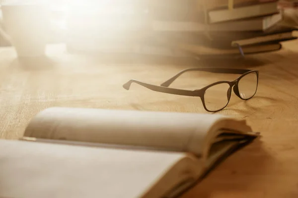 Close up of eyeglasses with books on wooden desk, Selective focus,  Flare sun light,Vintage tone. — Stock Photo, Image