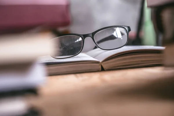 Primo piano di libro aperto con occhiali su scrivania in legno, Soft focus — Foto Stock
