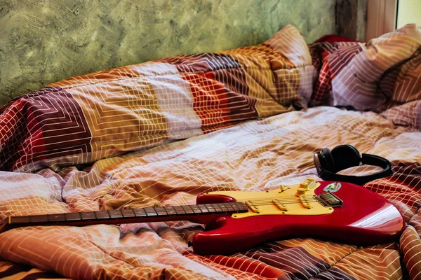 Elektro gitar ve kulaklık yatak odasında, filtre film tahıl.