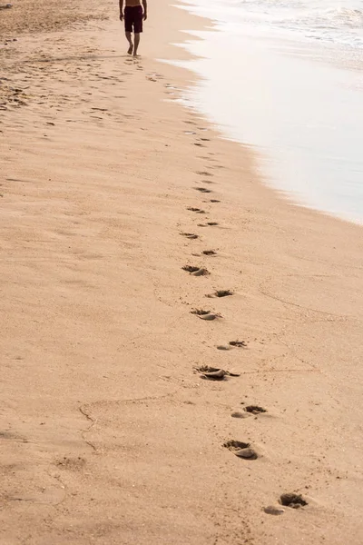 Lábnyomok egy férfi sétált a tengerparton. Utazási koncepció — Stock Fotó