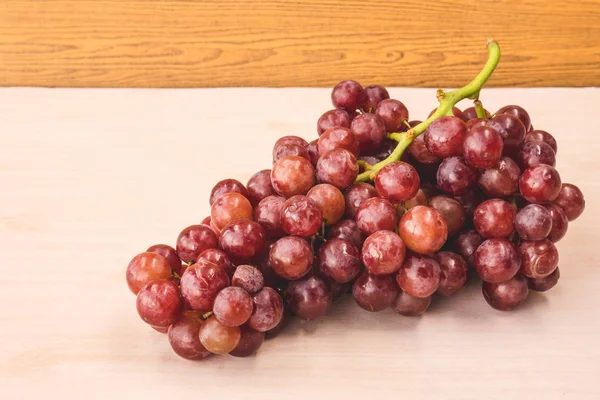 Uvas rojas en la mesa de madera . — Foto de Stock